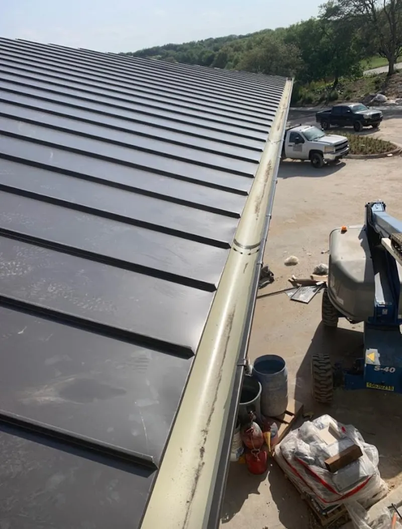 Standing seam panel and gutter detail on a metal roofing jobsite in Ypsilanti